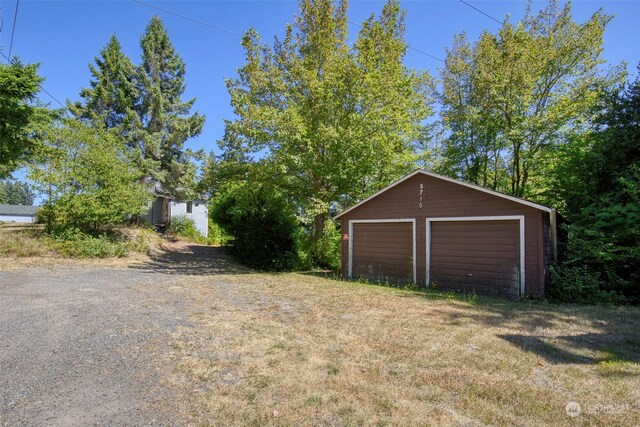 view of yard featuring a garage and an outdoor structure