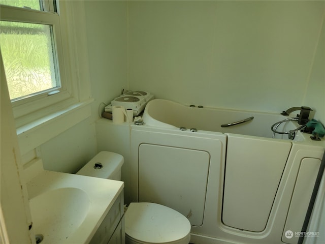 bathroom featuring toilet, plenty of natural light, and vanity