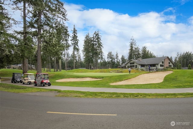 view of home's community with golf course view and a yard