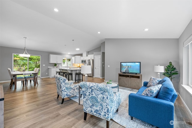 living room featuring light wood-style floors, recessed lighting, vaulted ceiling, and baseboards