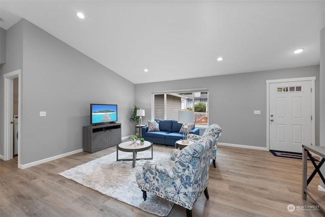 living room featuring vaulted ceiling, light wood-style flooring, and baseboards