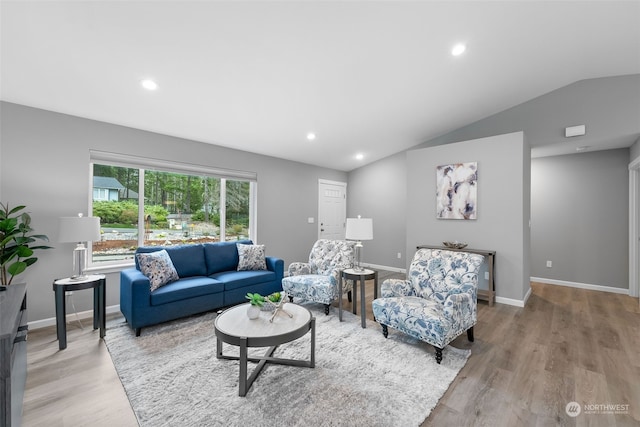 living room featuring lofted ceiling, light wood finished floors, recessed lighting, and baseboards