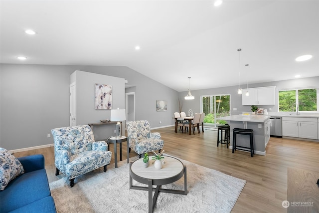 living area featuring vaulted ceiling, baseboards, light wood-style flooring, and recessed lighting