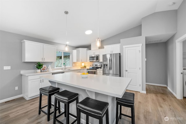 kitchen with stainless steel appliances, white cabinets, and light countertops