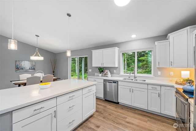 kitchen featuring hanging light fixtures, light wood-style flooring, appliances with stainless steel finishes, and white cabinets