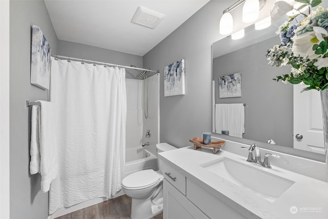 full bathroom with toilet, shower / tub combo, wood finished floors, and vanity