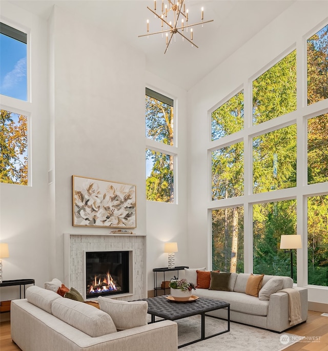 living room with wood-type flooring, high vaulted ceiling, and a notable chandelier