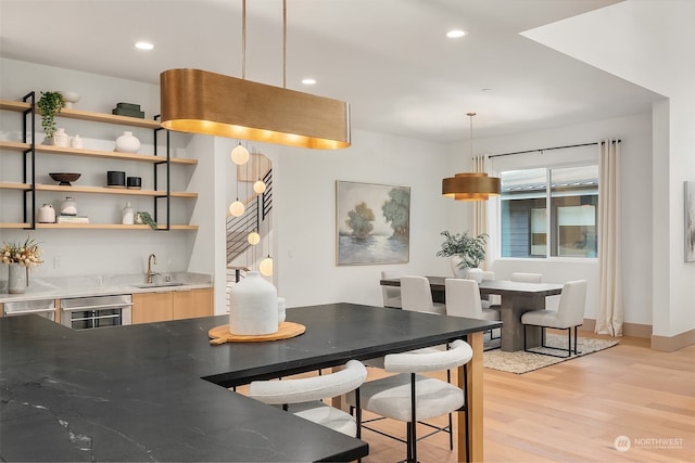 dining room with wine cooler, sink, and light wood-type flooring