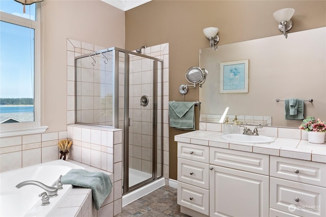 bathroom featuring shower with separate bathtub, a healthy amount of sunlight, and a water view