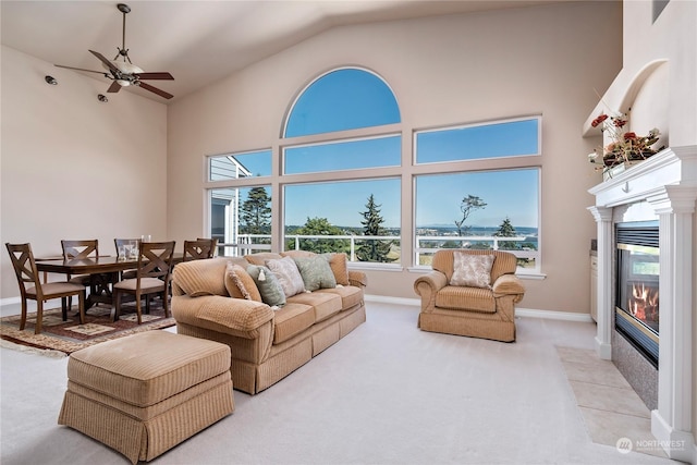 living room featuring ceiling fan, high vaulted ceiling, and light carpet