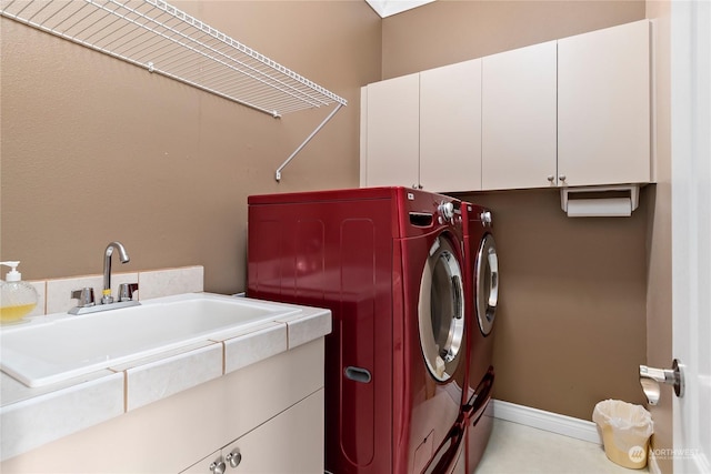 washroom with cabinets, sink, and washing machine and clothes dryer