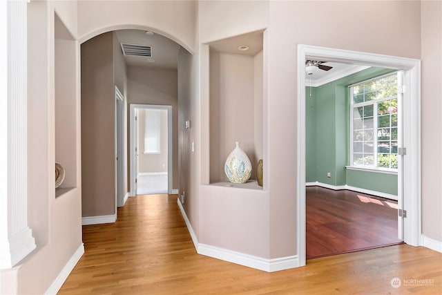 hall featuring ornamental molding and light hardwood / wood-style floors