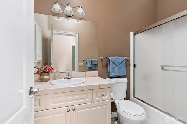 full bathroom featuring toilet, vanity, and shower / bath combination with glass door