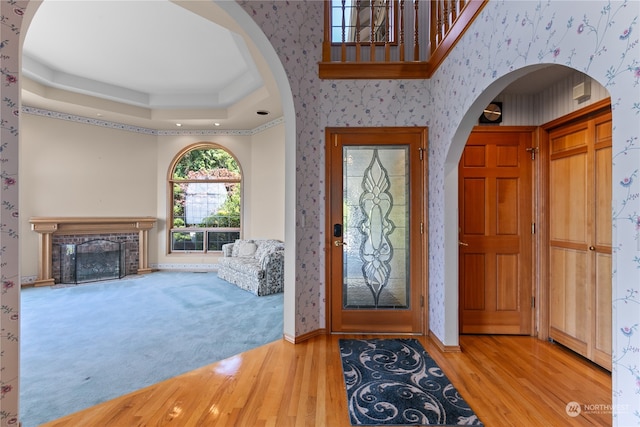 foyer with light hardwood / wood-style floors and a tray ceiling