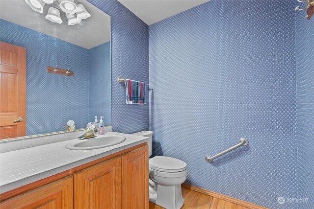 bathroom featuring vanity, toilet, and hardwood / wood-style flooring