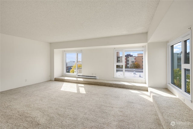 carpeted empty room with a baseboard radiator and a textured ceiling