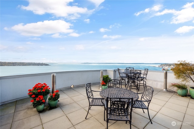 view of patio / terrace featuring a beach view and a water view