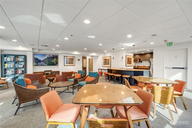 dining area featuring light carpet and bar area