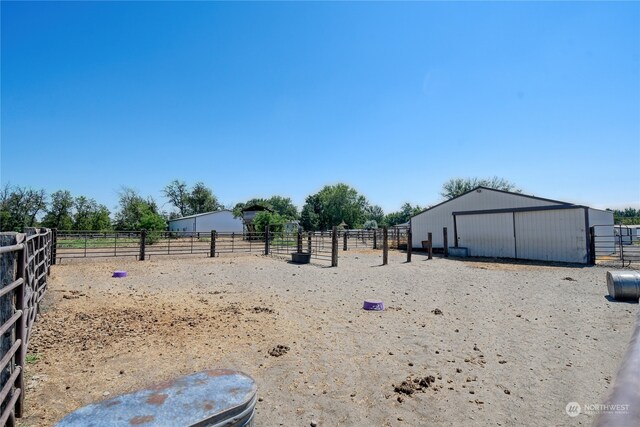 view of yard featuring a rural view and an outdoor structure