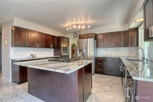 kitchen featuring rail lighting, light tile patterned floors, backsplash, light stone countertops, and sink