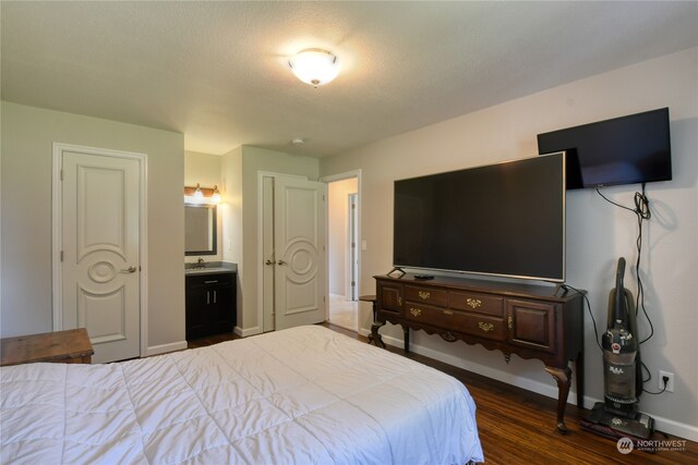 bedroom with sink, ensuite bath, and hardwood / wood-style floors