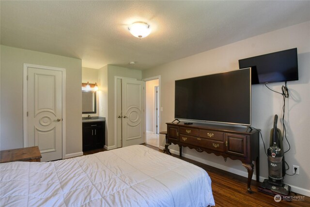 29495 Knight Rd, Hermiston, OR 97838 - bedroom with dark wood-type flooring, ensuite bathroom, baseboards, and a sink