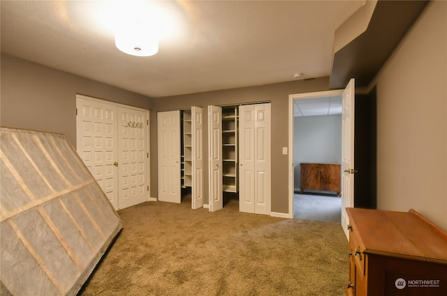 unfurnished bedroom featuring two closets and carpet