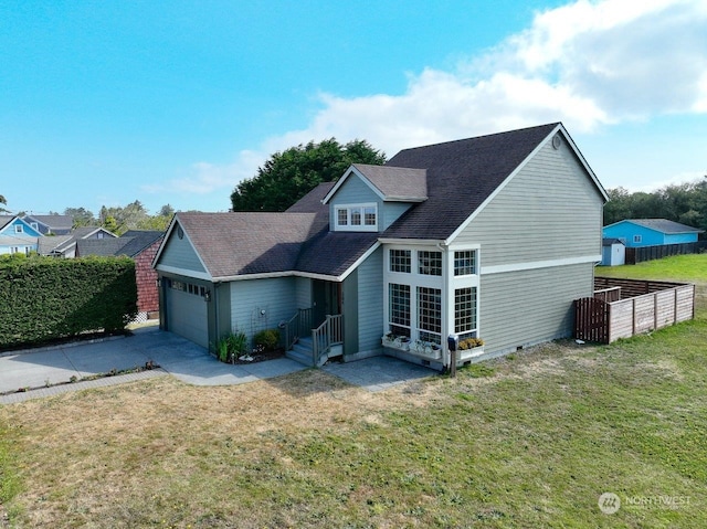 rear view of house with a garage and a lawn