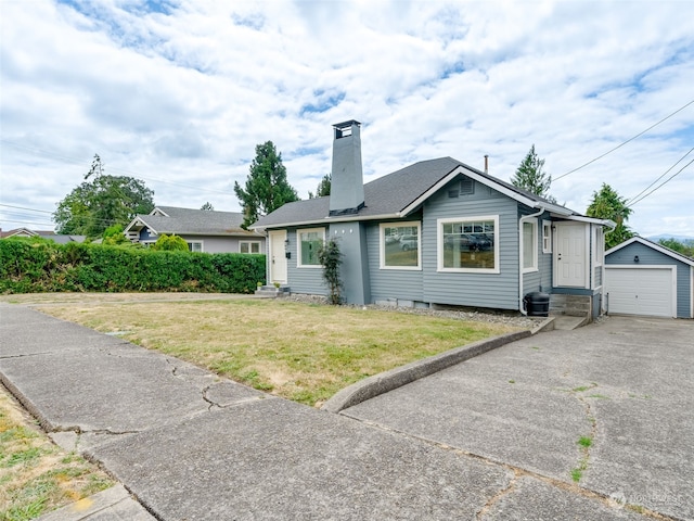 view of front of house featuring a garage, an outbuilding, and a front yard