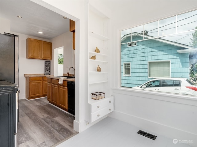 interior space with dark wood-type flooring, built in shelves, sink, stainless steel refrigerator, and dishwasher