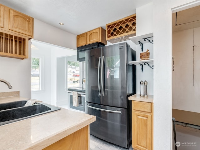 kitchen featuring sink, stainless steel refrigerator, and light brown cabinets