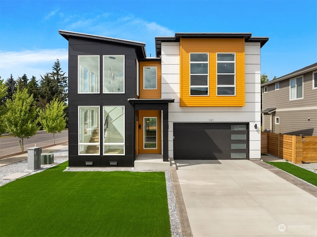 modern home with a garage, central air condition unit, and a front lawn