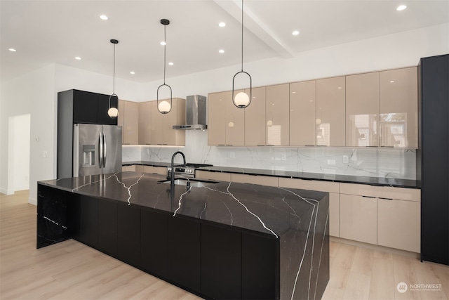 kitchen featuring backsplash, stainless steel fridge, light hardwood / wood-style flooring, and wall chimney exhaust hood