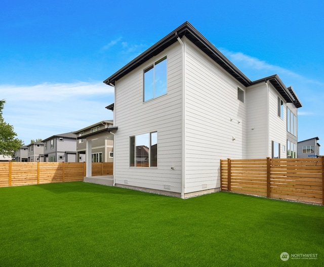 rear view of property featuring a patio area and a lawn