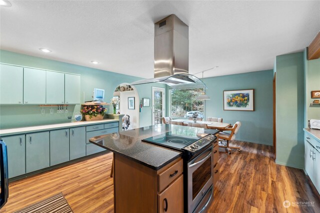 kitchen featuring dark wood-type flooring, stainless steel electric range, and island range hood