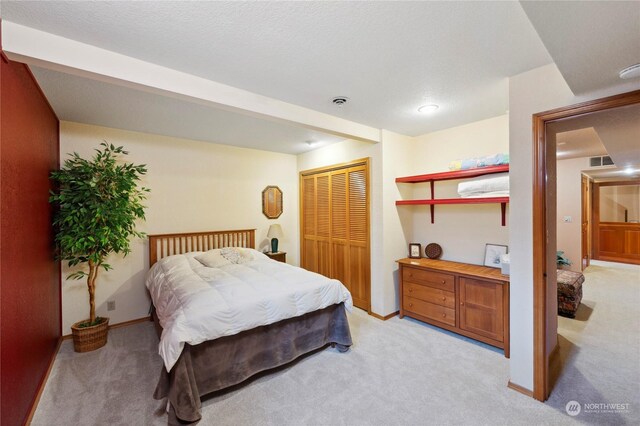 carpeted bedroom with a textured ceiling and a closet