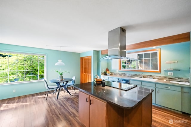 kitchen with sink, light hardwood / wood-style flooring, a center island, island exhaust hood, and pendant lighting