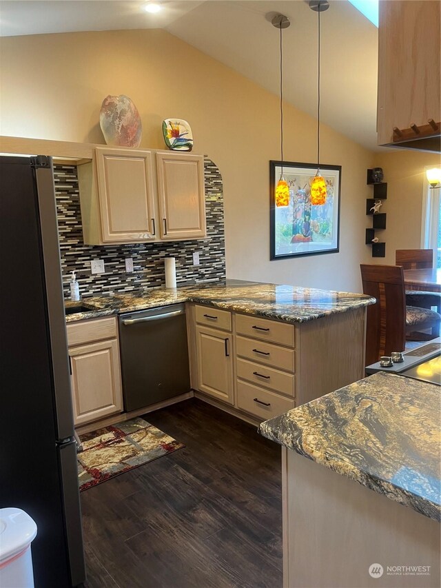 kitchen featuring light stone counters, refrigerator, vaulted ceiling, and stainless steel dishwasher