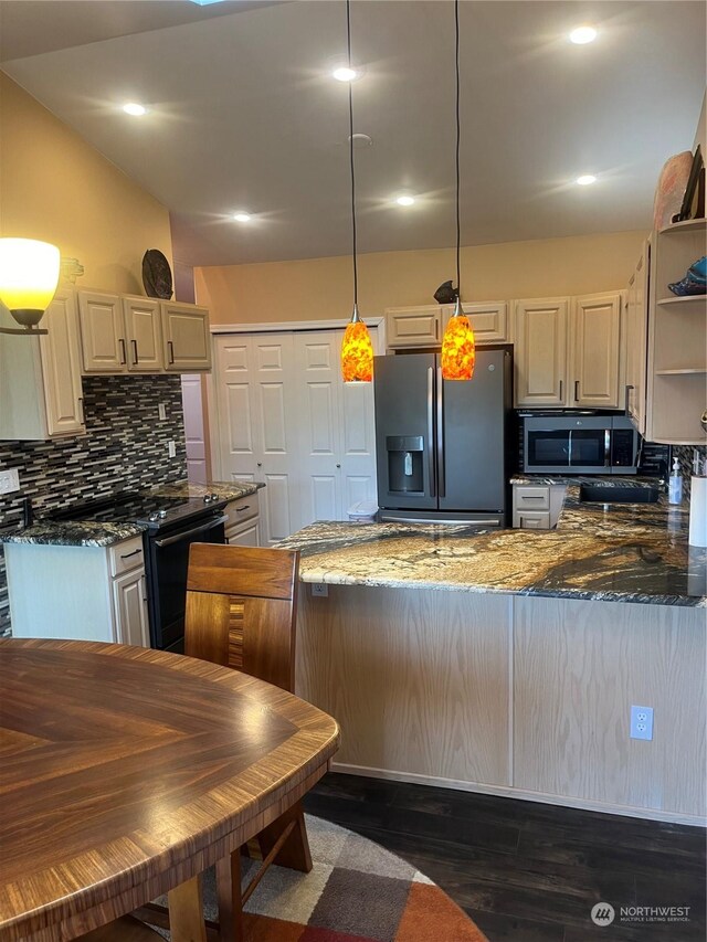 kitchen with tasteful backsplash, stainless steel appliances, dark stone countertops, hanging light fixtures, and dark hardwood / wood-style floors