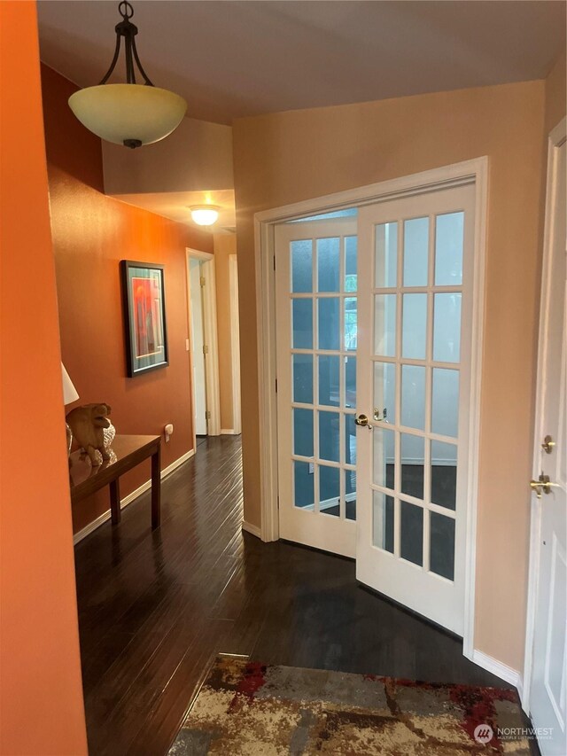 hall with dark hardwood / wood-style flooring, french doors, and vaulted ceiling