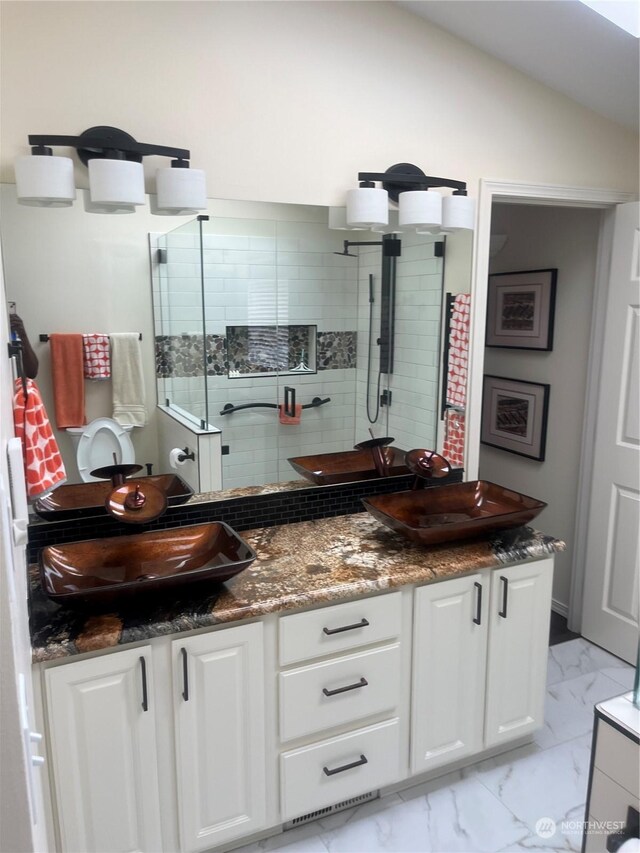 bathroom featuring lofted ceiling, double vanity, and tile patterned flooring