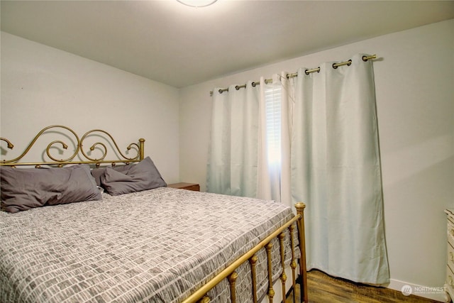 bedroom with dark hardwood / wood-style flooring