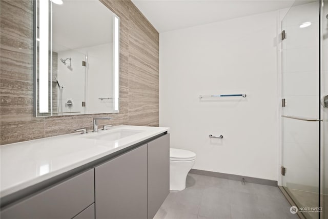 bathroom featuring vanity, an enclosed shower, tile walls, and toilet