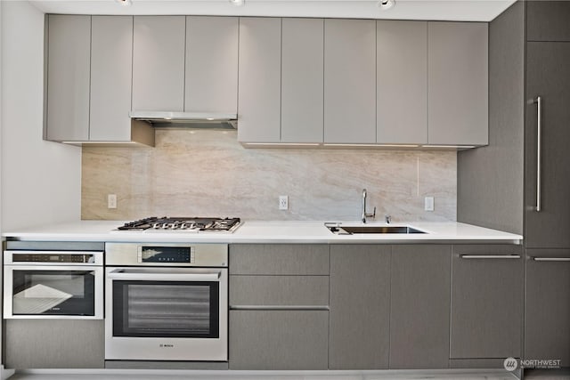 kitchen with sink, backsplash, gray cabinets, and stainless steel appliances