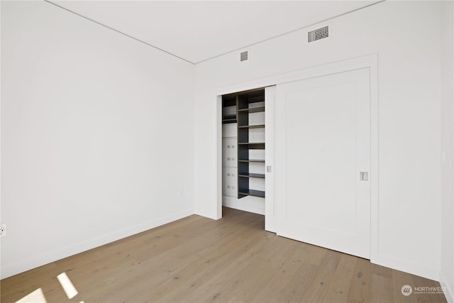 unfurnished bedroom featuring light hardwood / wood-style floors and a closet