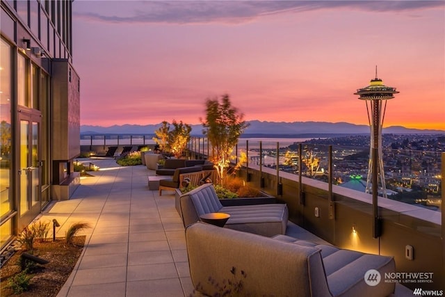 patio terrace at dusk featuring a mountain view and outdoor lounge area