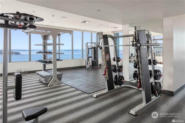 exercise room with a water view