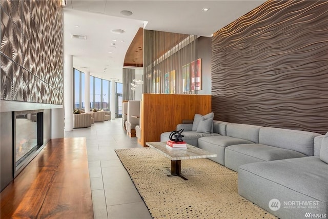 living room featuring light tile patterned flooring and a wall of windows