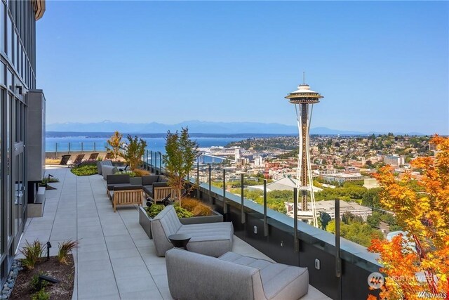 balcony featuring a water and mountain view and an outdoor hangout area