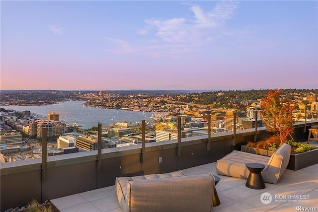 patio terrace at dusk with a balcony and a water view